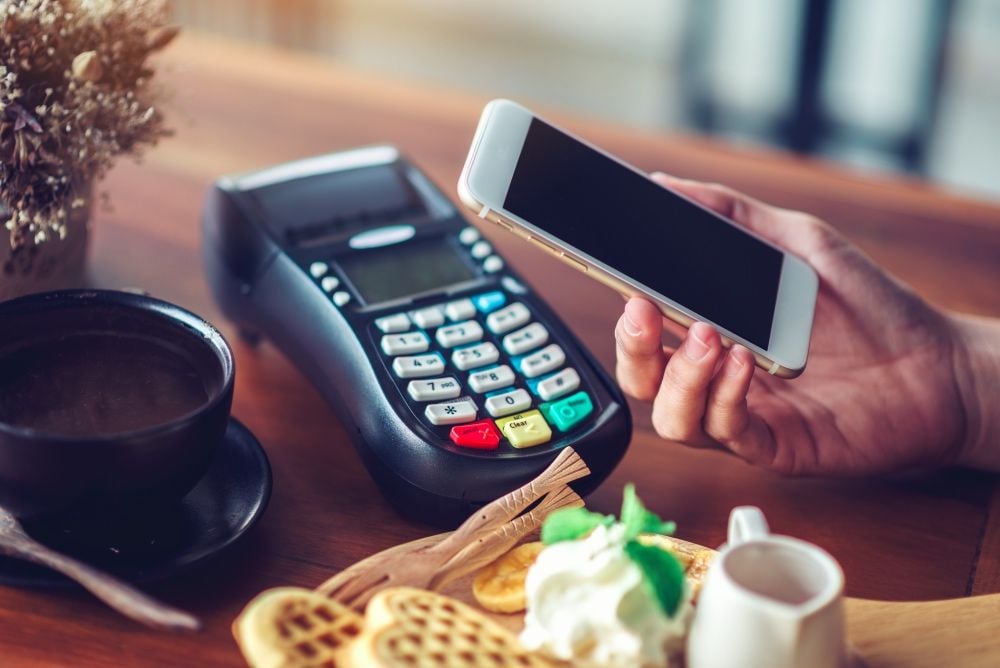 Customer making a mobile payment at a cafe
